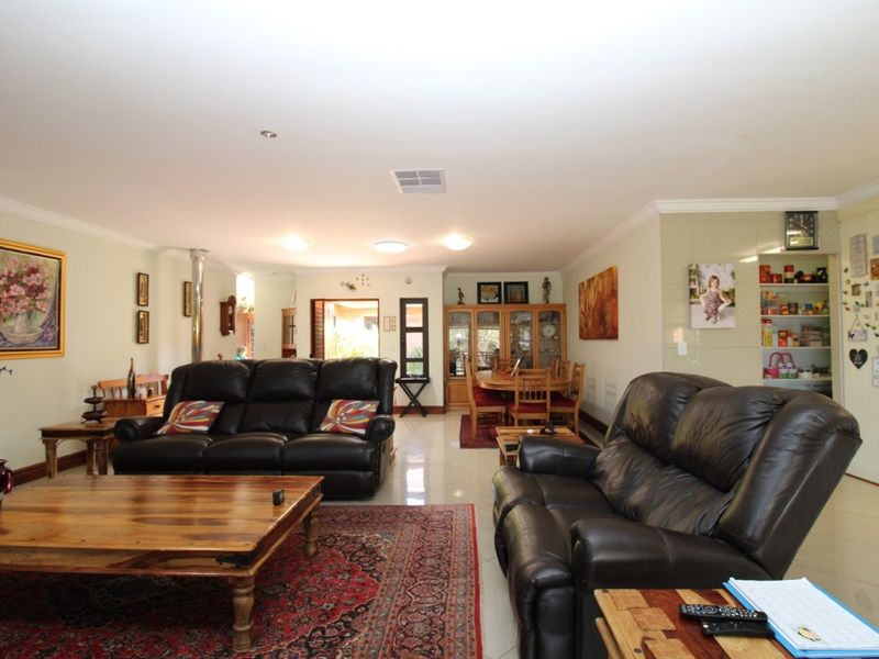 Spacious open-plan living and dining area featuring tiled flooring, recessed lighting, and a dedicated pantry nook.