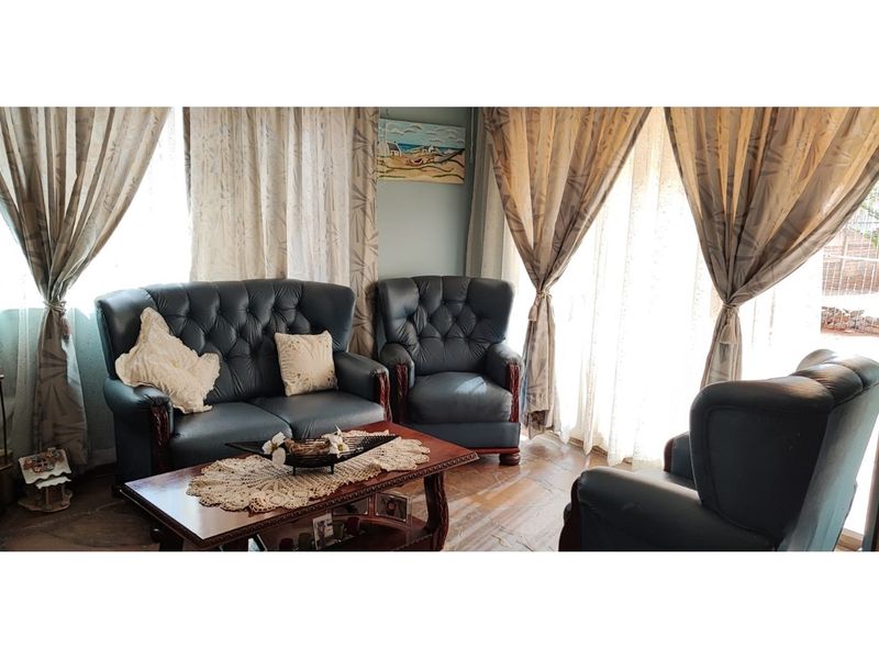 A comfortable living room featuring tiled flooring and a large sliding glass door that provides natural light and access to the exterior.