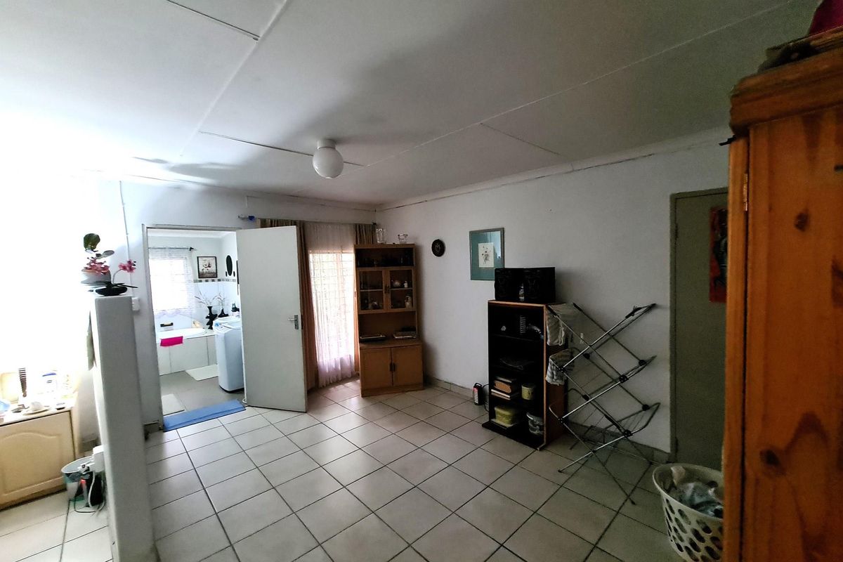 A functional living area featuring tiled flooring and direct access to an adjoining bathroom, providing a practical layout for daily living.