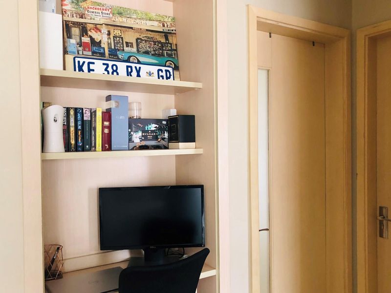 A built-in study nook featuring integrated shelving and a desk space, adjacent to interior wooden doors.