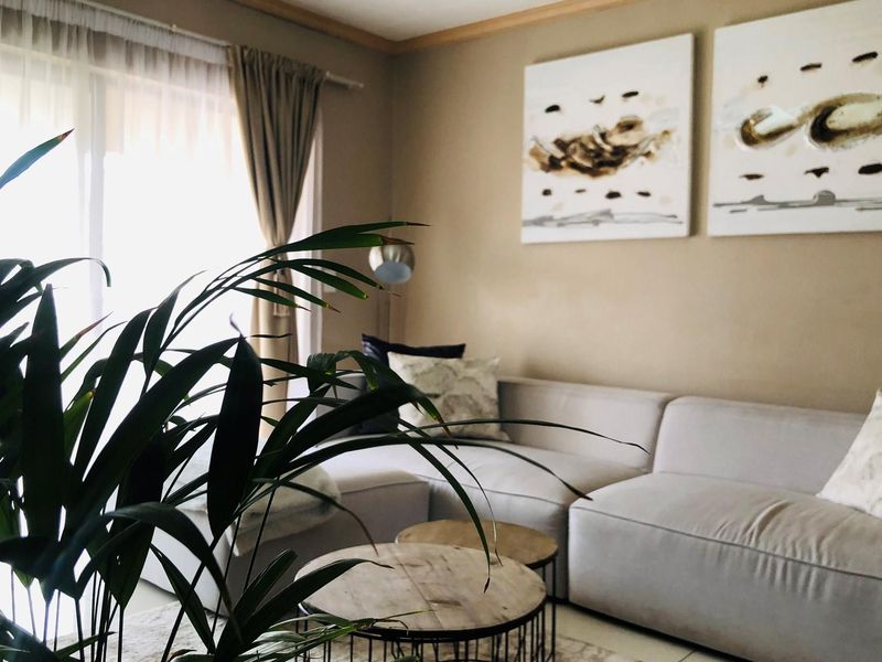 A comfortable living room featuring neutral wall tones, large sliding glass doors providing natural light, and a clean, inviting atmosphere.