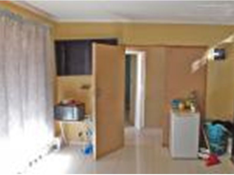 A living area featuring tiled flooring and internal doors, currently requiring cosmetic updates to improve the overall aesthetic and condition of the space.