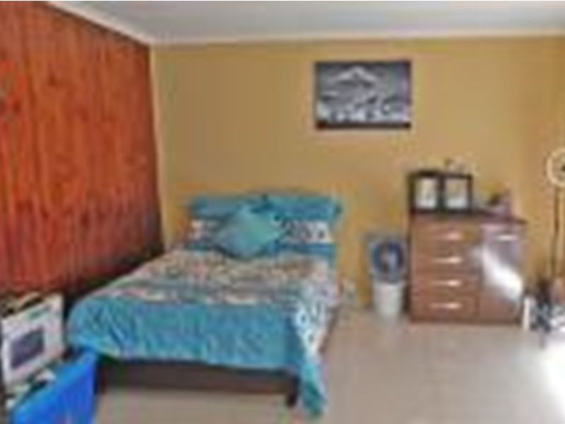 A bedroom featuring timber wall paneling and neutral wall finishes.