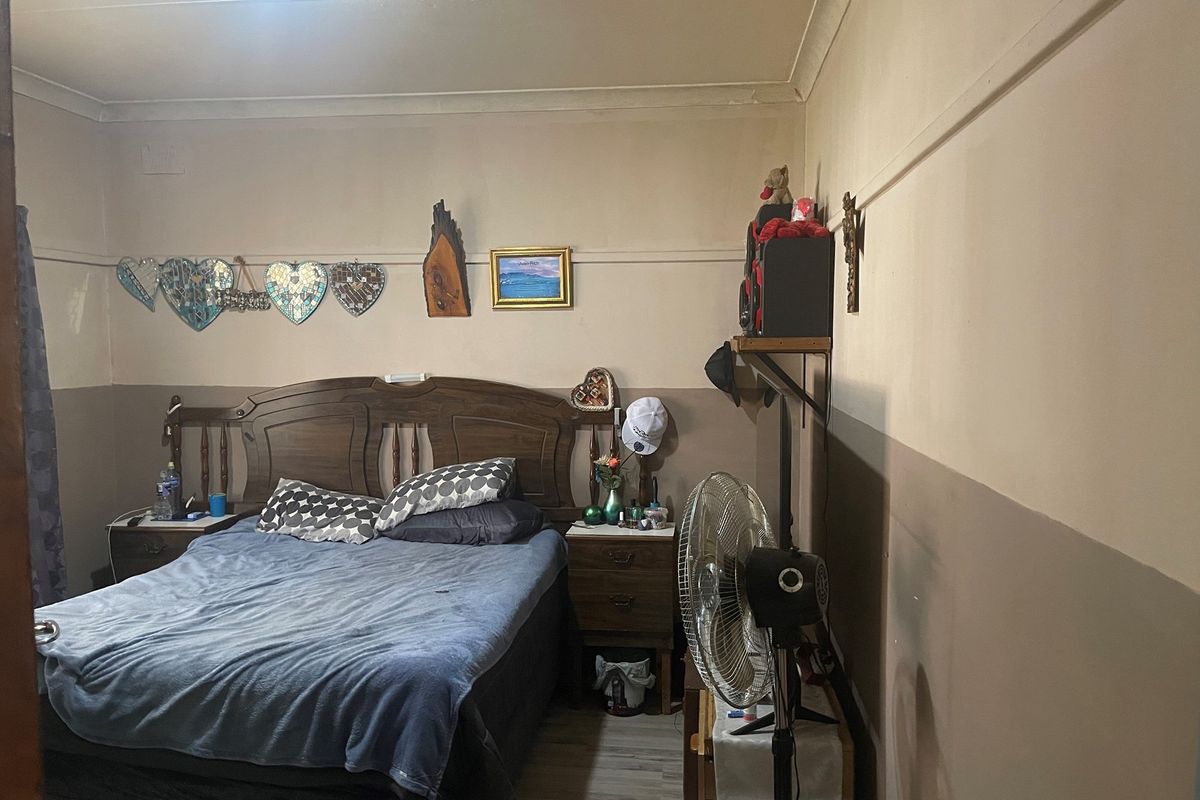 A bedroom featuring a two-tone painted wall finish and traditional crown molding, providing a functional sleeping space.