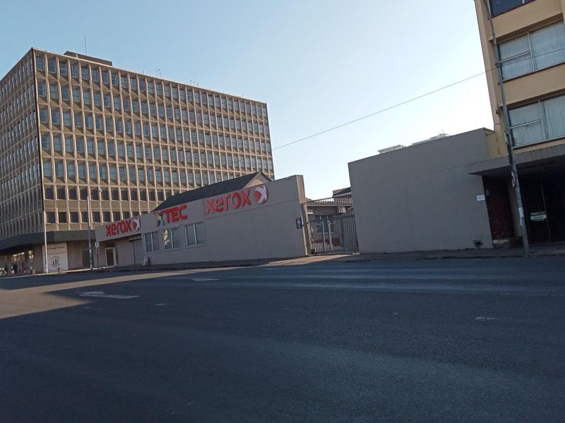 Street level view of a commercial building facade and surrounding urban infrastructure.