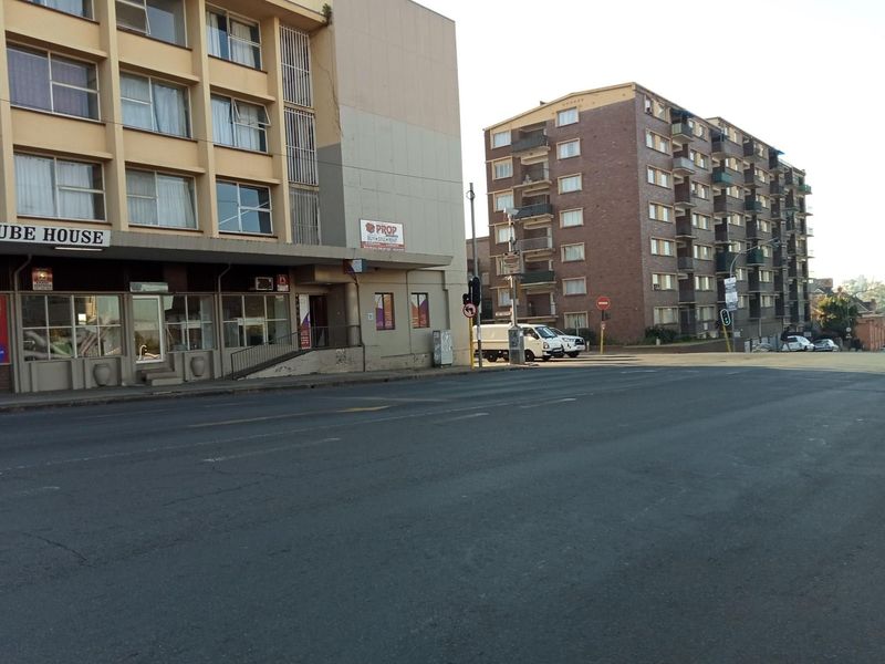 Street-level view of Dube House apartment building and surrounding urban infrastructure.