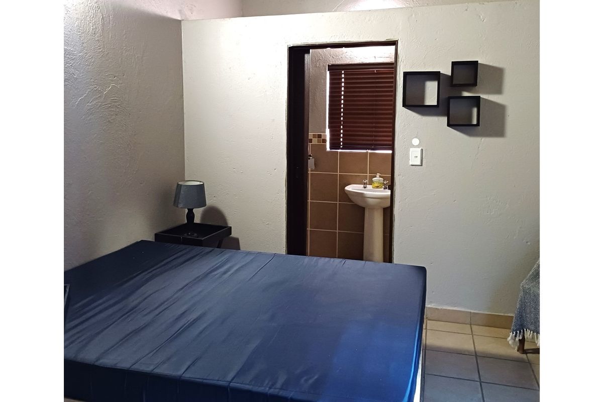 Bedroom featuring an en-suite bathroom with a pedestal basin and tiled splashback, requiring cosmetic updates to improve the overall finish.