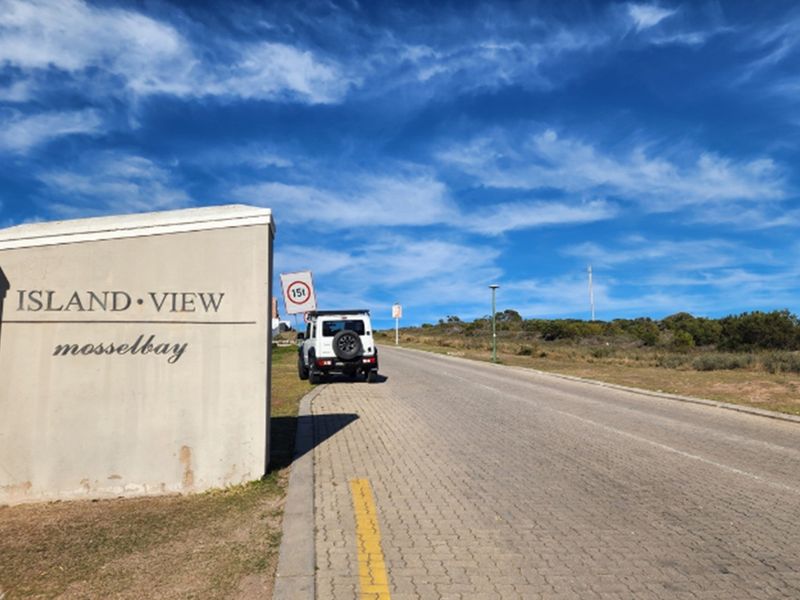 Street view of the Island View residential area in Mossel Bay, featuring paved roads and signage.