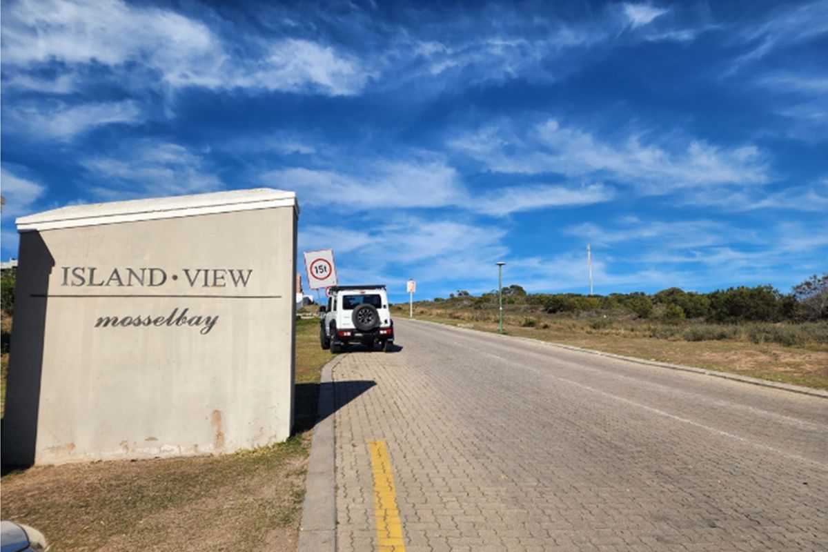 Street view of the Island View residential area in Mossel Bay, featuring paved roads and signage.