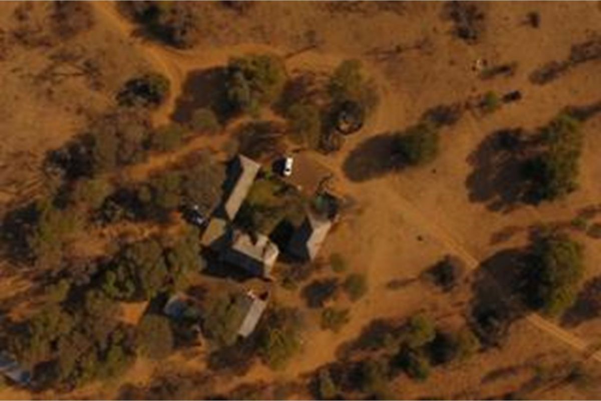Aerial view of the farm property showing the main dwelling and surrounding outbuildings set within a rural landscape.