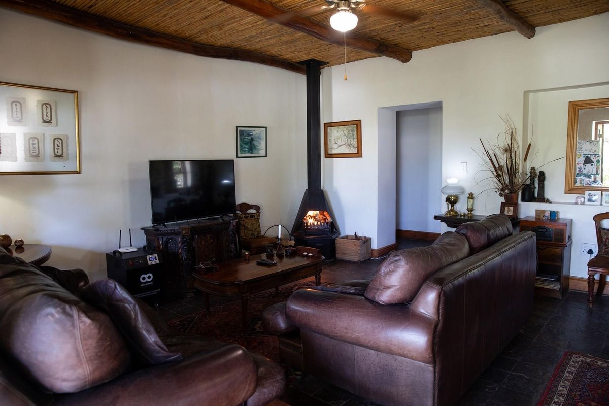 Cozy living room featuring a rustic reed ceiling, slate tile flooring, and a built-in black metal fireplace.