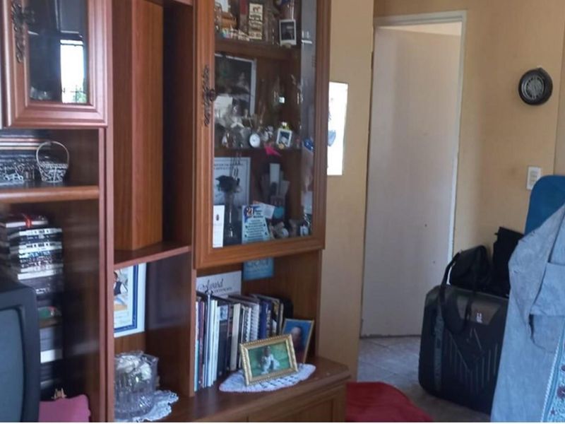 A view of a living area featuring built-in cabinetry and a doorway leading to an adjacent room.