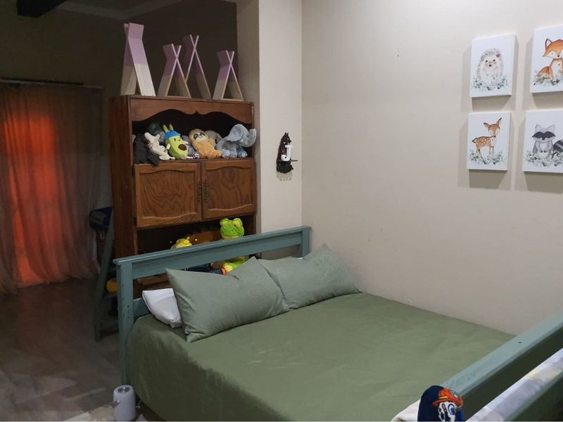 A bedroom featuring neutral wall finishes and tiled flooring, providing a functional space with access to an adjacent area.