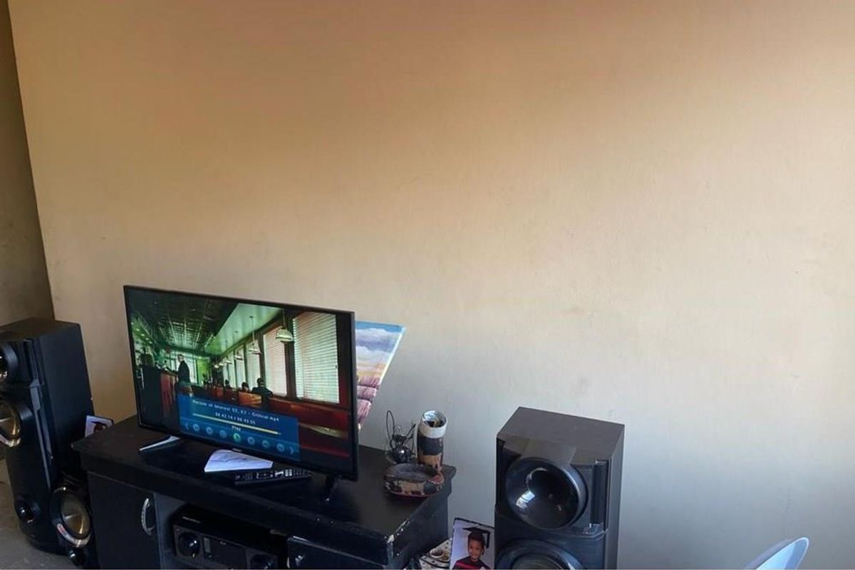 A living room area featuring a plain wall surface, suitable for personalization or decorative updates.