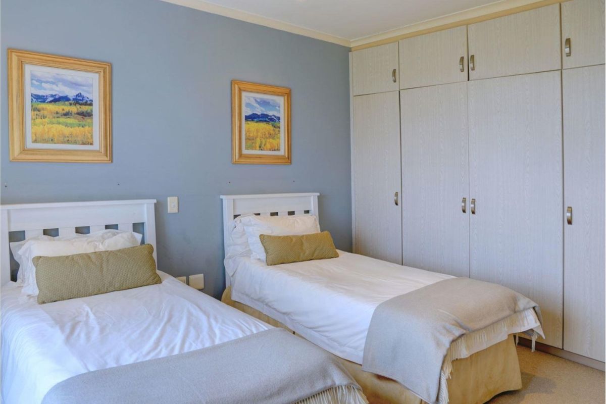 A bedroom featuring built-in floor-to-ceiling cabinetry with light wood-grain finish and neutral wall paint.