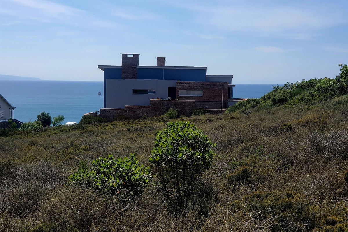 A view of a modern residential property featuring brick and rendered exterior walls, set against a scenic coastal backdrop.