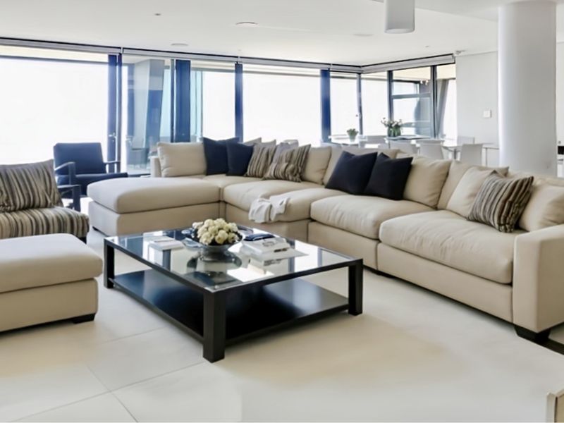 Spacious open-plan living area featuring large format floor tiles, recessed lighting, and expansive floor-to-ceiling sliding glass doors providing abundant natural light.