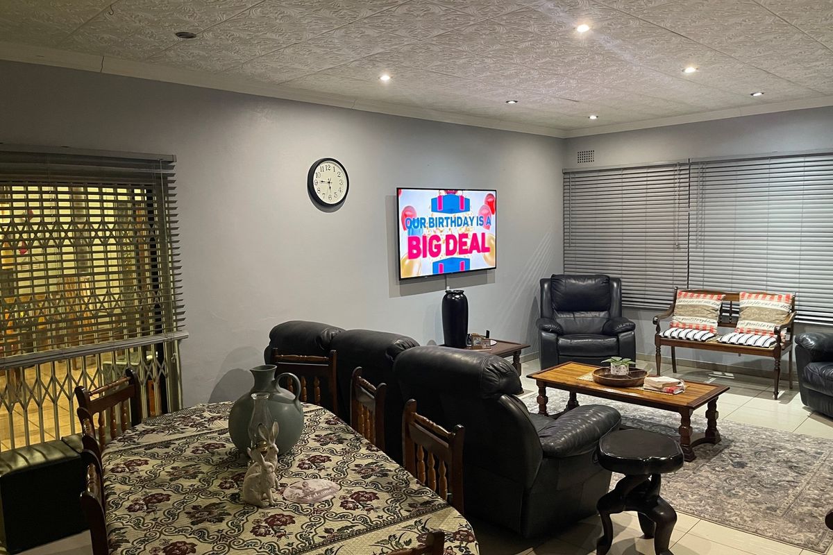 A spacious living area featuring tiled flooring, recessed ceiling lighting, and decorative ceiling tiles, providing a comfortable and functional space for relaxation.