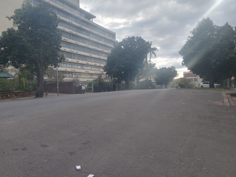 A street-level view showing the surrounding neighbourhood and approach to the apartment building.