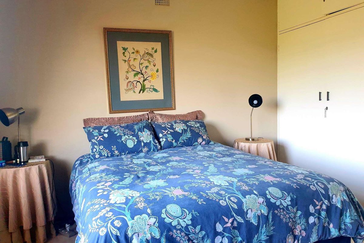A bedroom featuring built-in cupboards and neutral wall finishes.