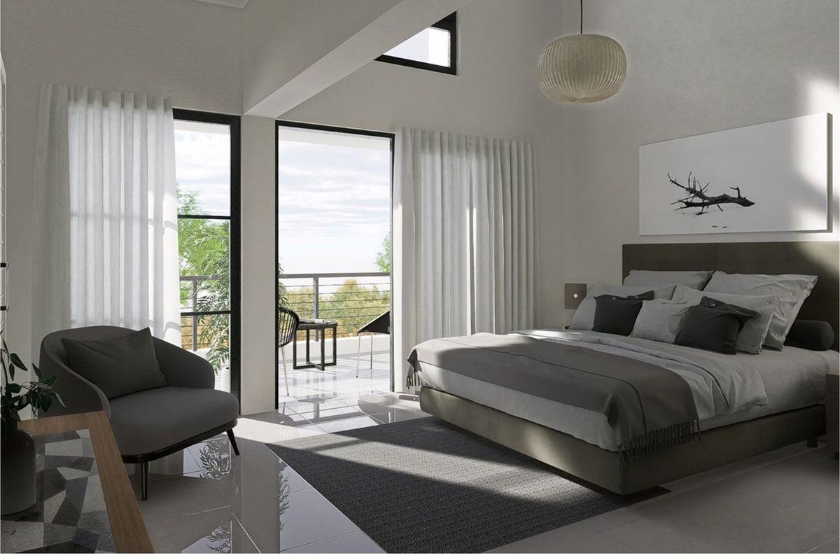 Spacious bedroom featuring high vaulted ceilings, large windows, and direct access to a private balcony with scenic views.