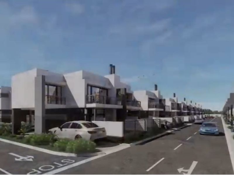 A street-level view of a modern residential apartment complex featuring contemporary architectural design and paved access roads.