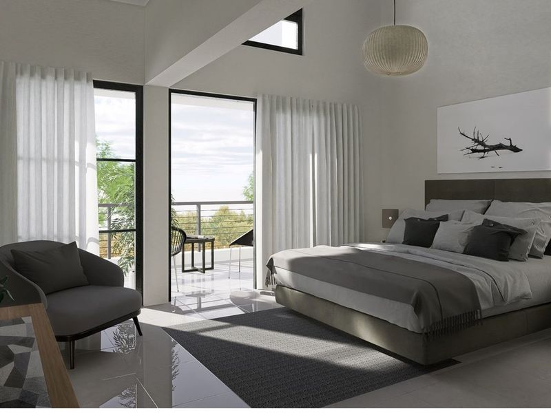 Spacious bedroom featuring high vaulted ceilings, large windows, and direct access to a private balcony with scenic views.