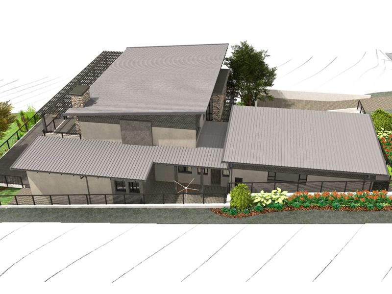 An aerial perspective of a modern residential property featuring a metal roof, stone chimney, and landscaped garden areas.