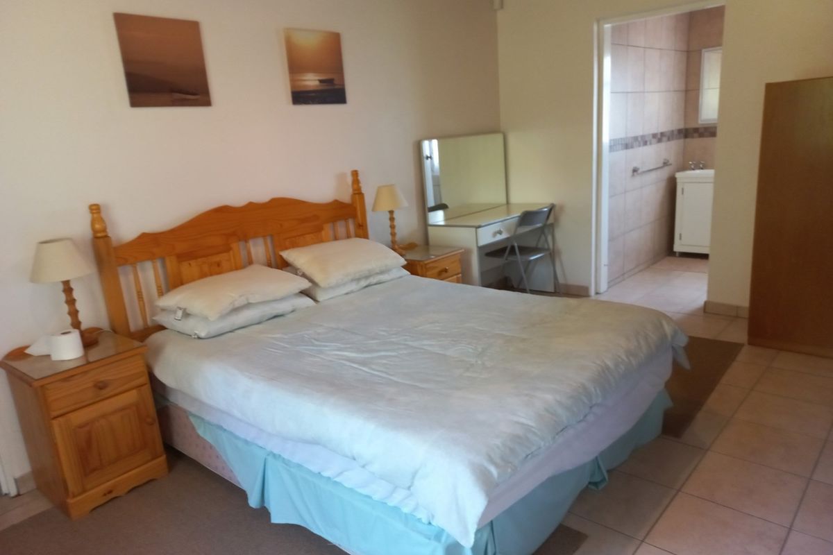 A bedroom featuring tiled flooring and an en-suite bathroom, providing a functional and comfortable living space.