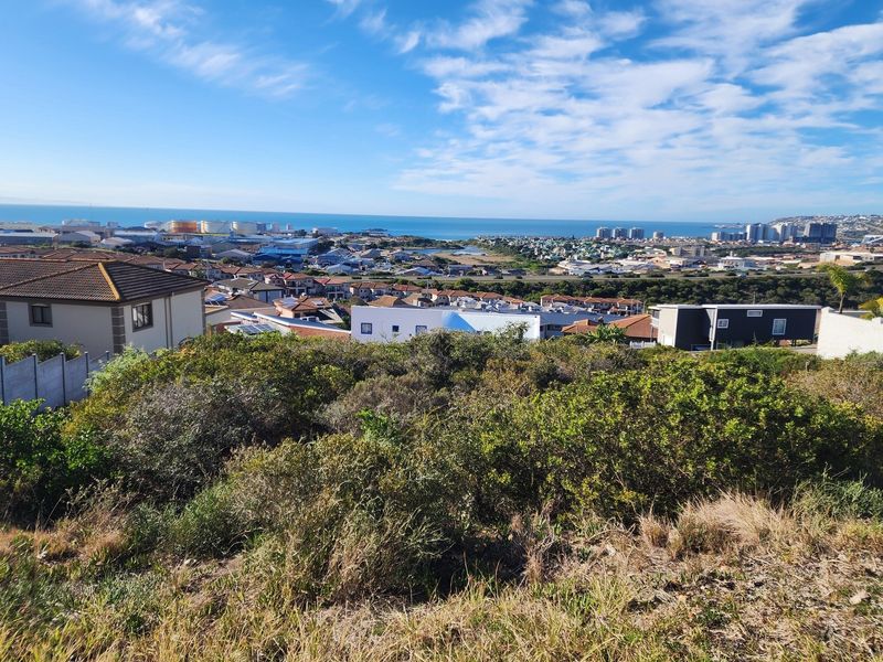 Elevated view overlooking the surrounding residential neighborhood and distant coastline, showcasing the potential of this vacant land plot.