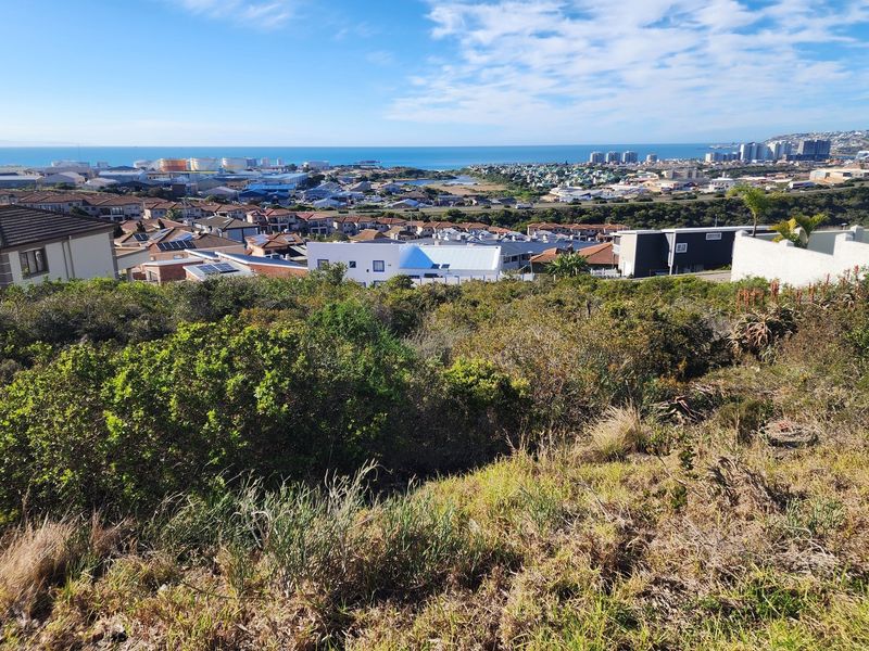 Elevated view overlooking the surrounding residential neighborhood and distant coastline from the vacant land plot.