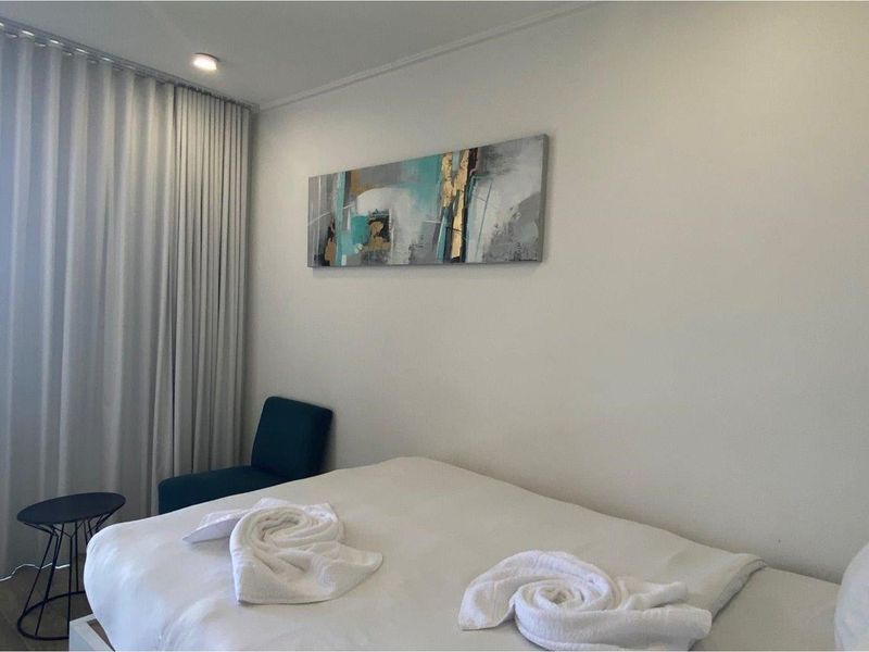 A well-maintained bedroom featuring floor-to-ceiling curtains and recessed ceiling lighting.