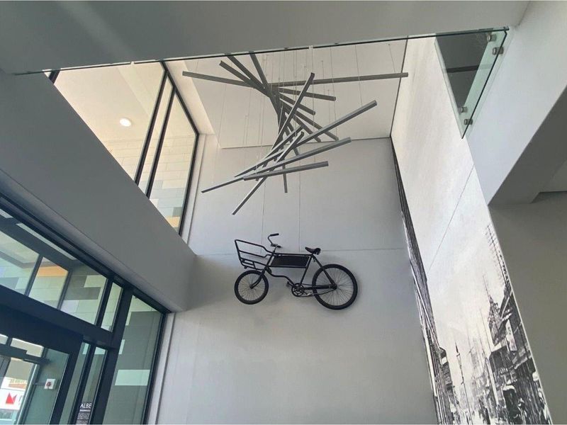A double-volume entrance hall featuring high ceilings, large glass windows, and a modern architectural design with a contemporary light fixture.