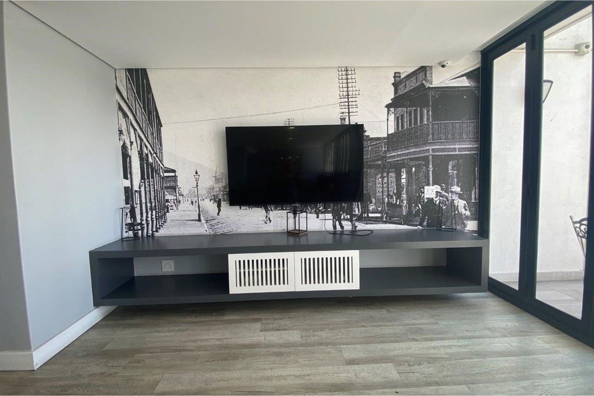 A modern living room featuring a sleek, wall-mounted floating media console and a large feature wall with a historical mural.