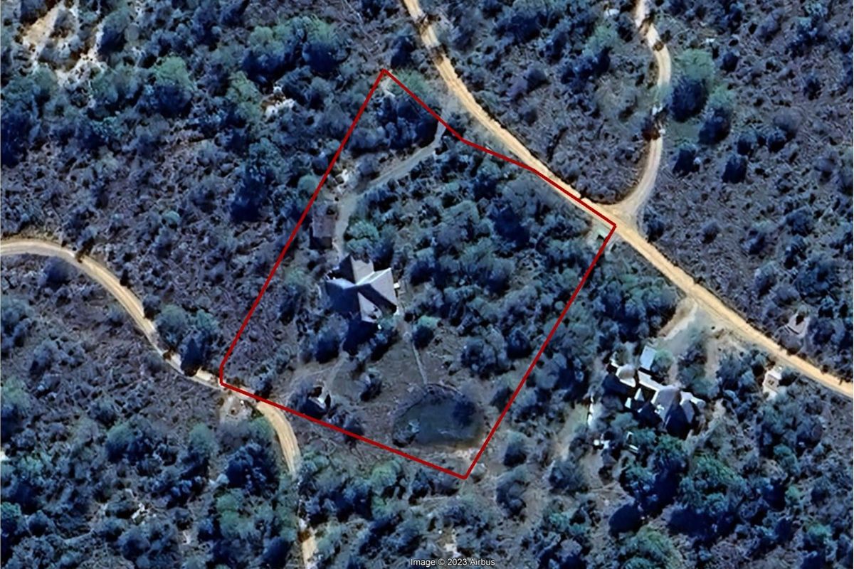 Aerial view of the property showing the building footprint, surrounding natural landscape, and site boundaries.