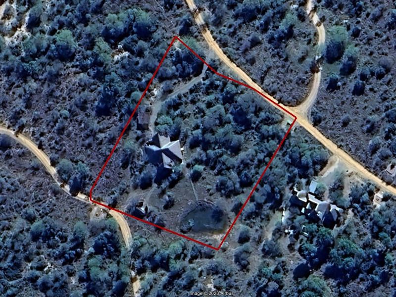 Aerial view of the property showing the building footprint, surrounding natural landscape, and site boundaries.