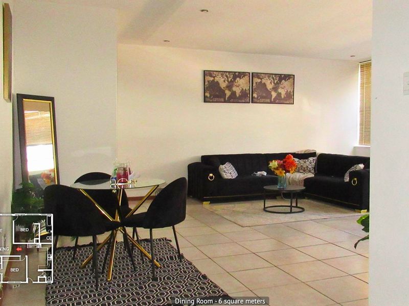 Open plan living and dining area featuring tiled flooring and neutral walls, providing a versatile space for relaxation and meals.