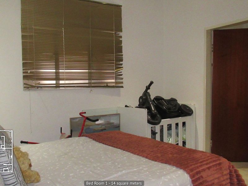 A bedroom featuring tiled flooring and venetian blinds, requiring minor repairs to window treatments and general cosmetic updates.