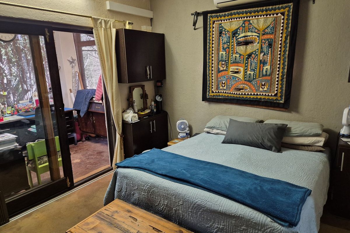 A bedroom featuring built-in cabinetry and sliding glass doors that provide access to an adjacent room or patio area.