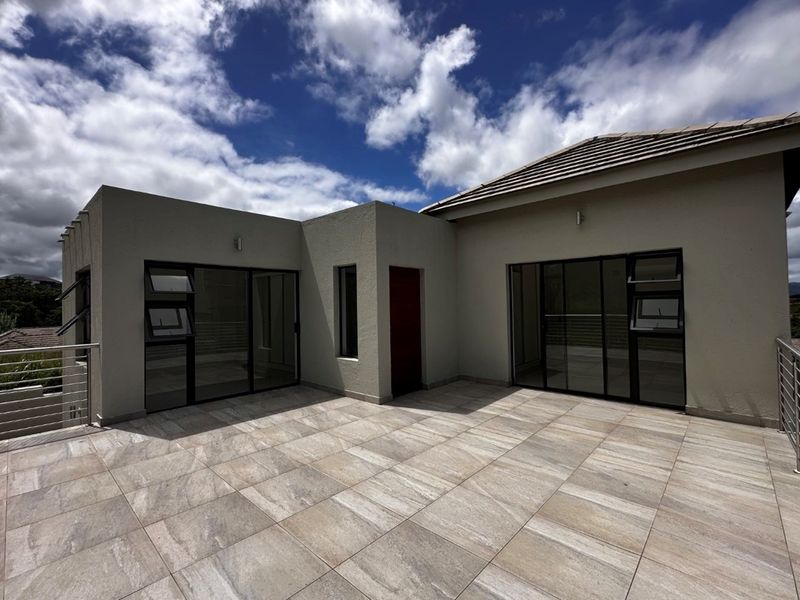 Spacious outdoor terrace featuring modern tiled flooring, aluminum-framed sliding doors, and stainless steel balustrades, offering a clean and well-maintained exterior living space.