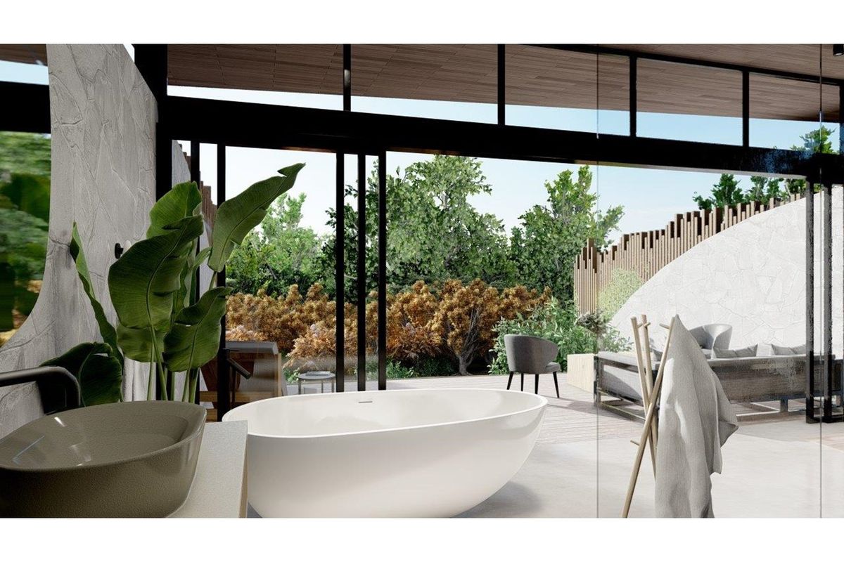 Modern bathroom featuring a freestanding bathtub and stone wall accents, seamlessly opening to a private outdoor patio area through large glass sliding doors.