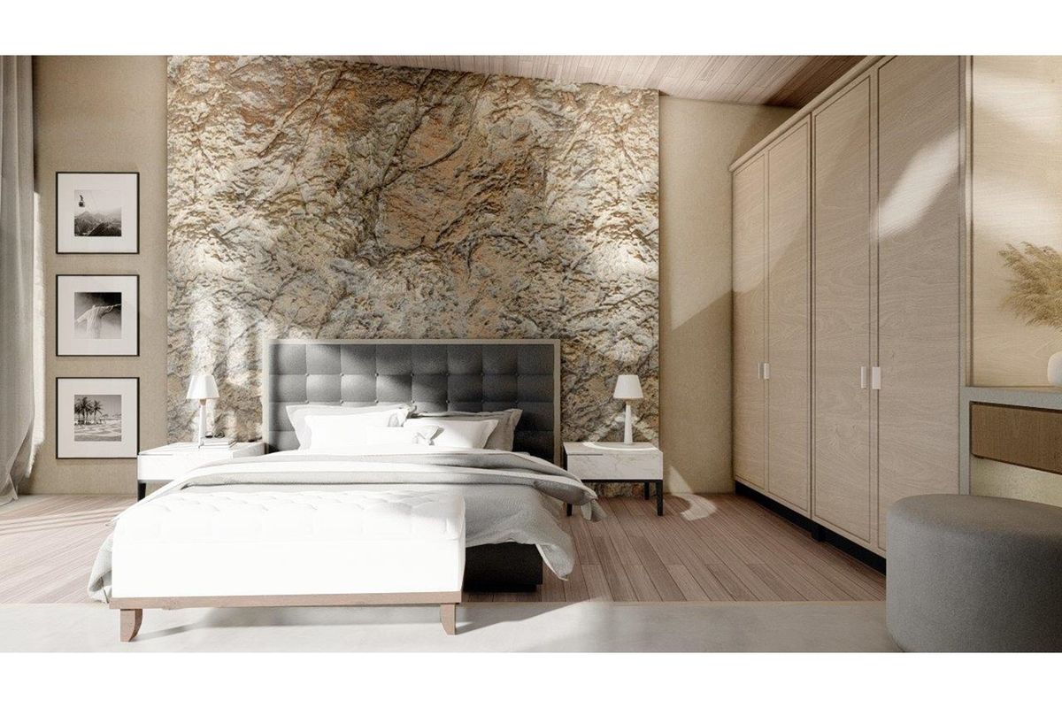 A modern bedroom featuring a textured stone accent wall, light wood flooring, and integrated floor-to-ceiling cabinetry.