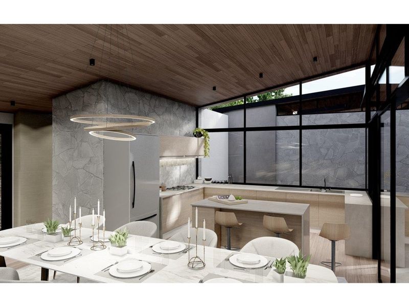 Modern open-plan kitchen and dining area featuring high-end cabinetry, stone wall accents, and large floor-to-ceiling windows with natural light.