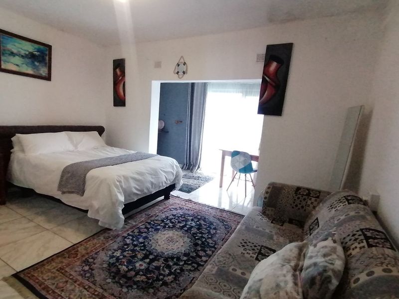 A bedroom featuring tiled flooring and a sliding door leading to an adjacent space, offering a functional layout with neutral wall finishes.