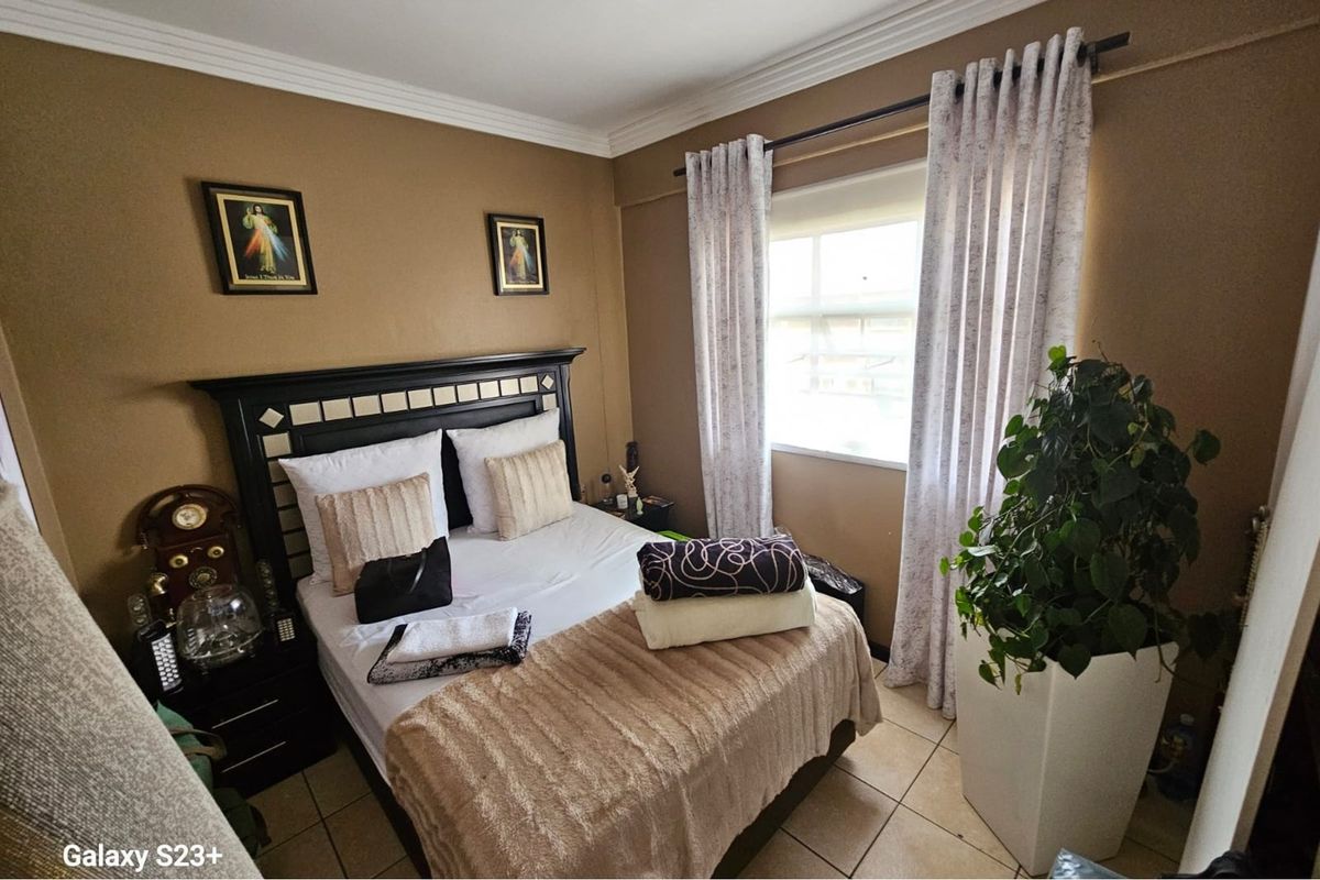A bedroom featuring tiled flooring, crown molding, and a window with curtain tracks.