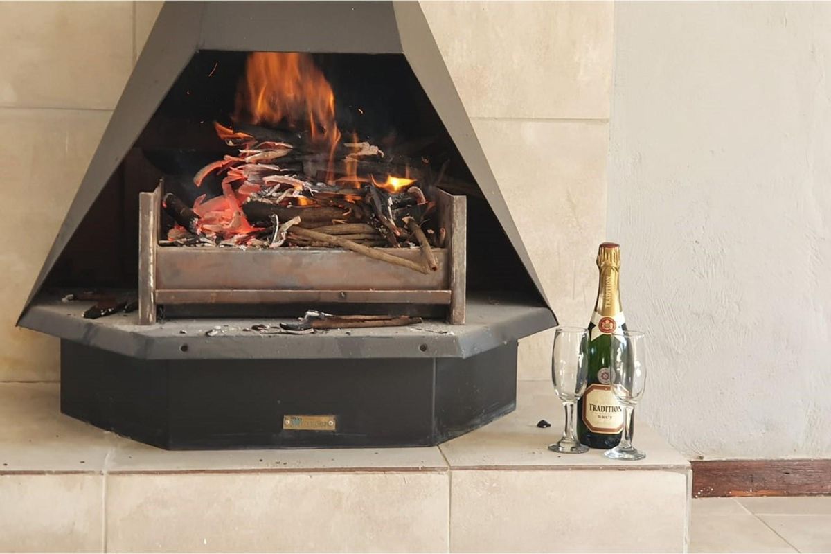 A cozy indoor fireplace featuring a black metal firebox and a tiled hearth, creating a warm and inviting atmosphere.