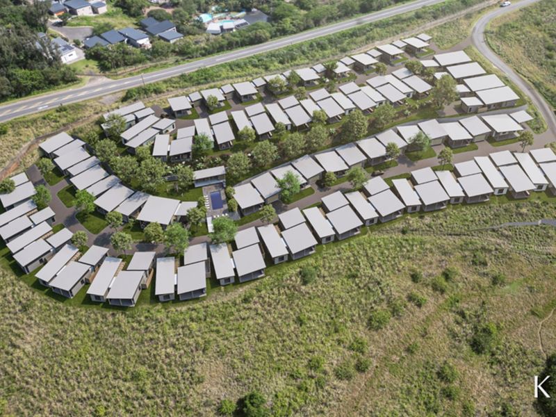 Aerial view of a modern residential estate development featuring multiple housing units, landscaped grounds, and a communal swimming pool.