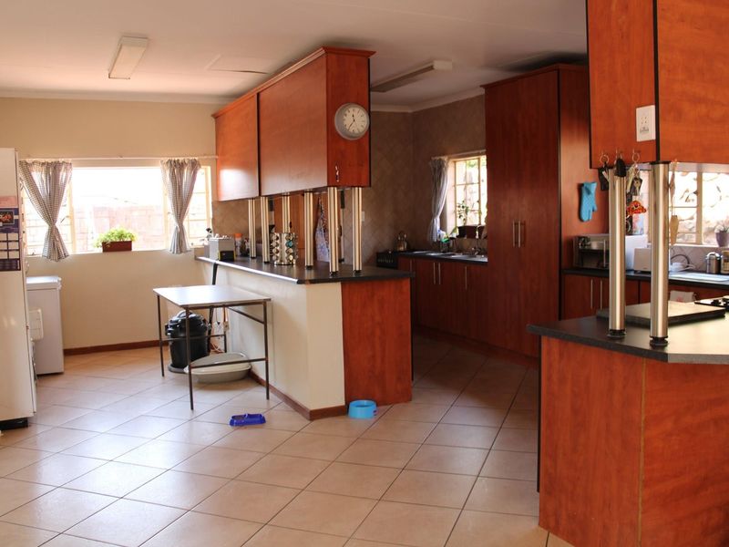 Spacious kitchen featuring extensive laminate cabinetry, dark countertops, and ceramic tile flooring, offering a functional layout with ample storage and prep space.