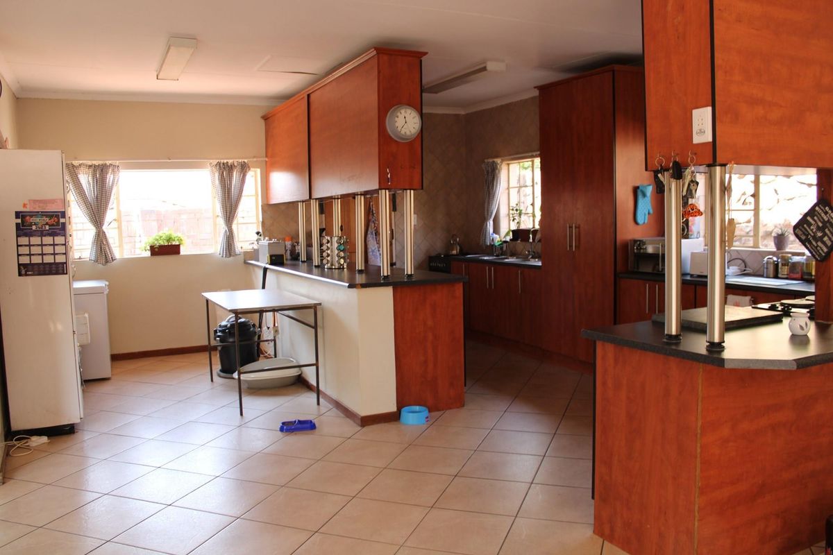Spacious kitchen featuring extensive laminate cabinetry, dark countertops, and ceramic tile flooring, offering a functional layout with ample storage and prep space.