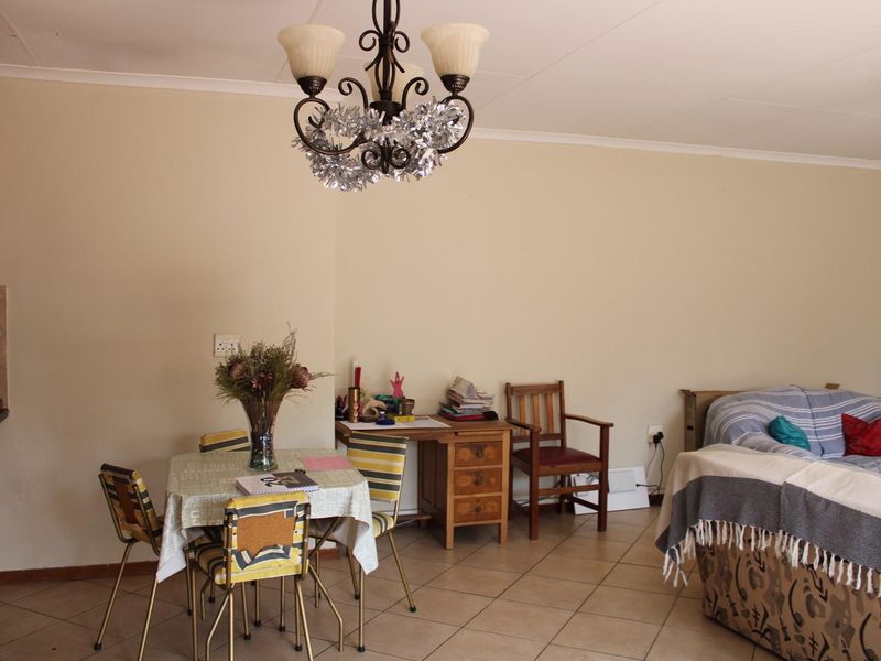 Open plan living and dining area featuring tiled flooring and a decorative chandelier, offering a versatile space for daily living.